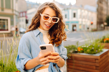 Beautiful woman using mobile in the Street. Youth concept.  Business, technology, blogging,...