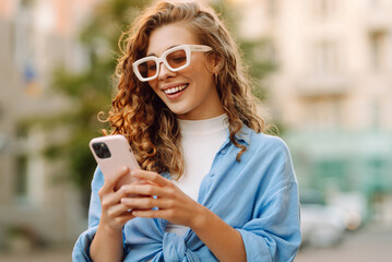 Beautiful woman using mobile in the Street. Youth concept.  Business, technology, blogging,...