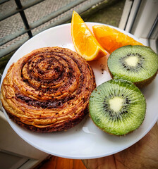 Cinnamon roll with kiwi and orange