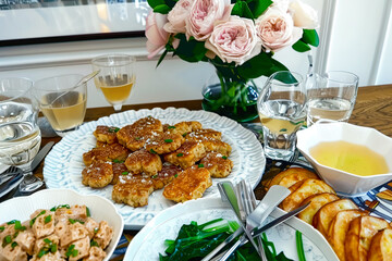 A plate of fish cakes on a table in a restaurant with flowers