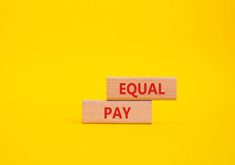 Equal Pay symbol. Wooden blocks with words Equal Pay. Beautiful yellow background. Business and...