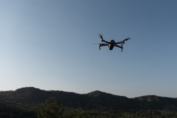 Drone airplane flying over in the sky to the mountains .