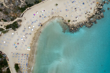 Drone view of idyllic sandy holiday beach. Konnos Bay beach people relaxing and enjoying summer...