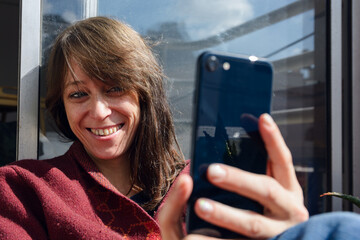 woman feels beautiful and takes selfie photo with her phone