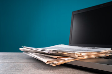 Newspapers on laptop, information, media concept, old and new sources of information