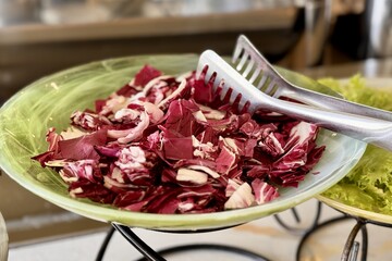 Salad red cabbage on light green dish in a beautiful bowl for buffet meals in a restaurant. Vegetables on a plate. Close-up