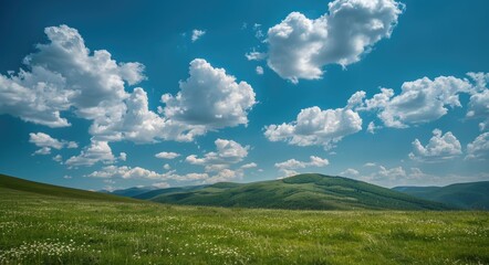 Countryside Landscape with Green Fields, Rolling Hills, and Mountain Peaks under Blue Sky