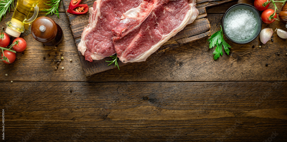 Poster two raw beef steak on wooden board on wood table with copy space top view