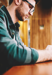 Cropped image of bearded male person wearing spectacles for eye protection texting email message...