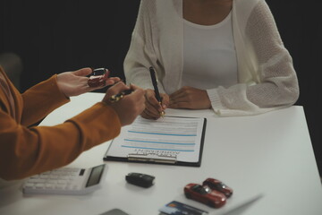 Insurance officers hand over the car keys after the tenant. have signed an auto insurance document...