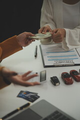 Insurance officers hand over the car keys after the tenant. have signed an auto insurance document...