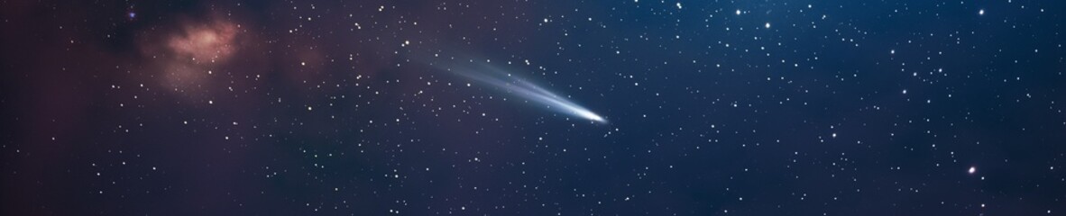 A comet in the starry sky. Comet flying in the universe with milky way galaxy on the background. Speeding comet with a long tale.