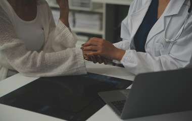 Obraz premium Asian female doctor giving hope and encourage to stressed woman patient at hospital. Smiling doctor woman touching on patient shoulder to support take care and helping . Supported and Encouraged