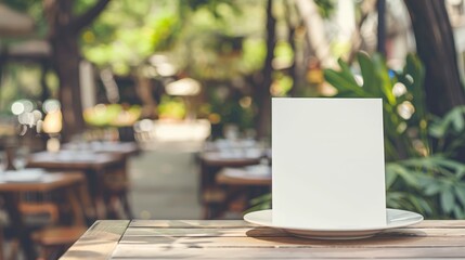 Blank dinner invitation mockup on restaurant table in garden. Empty white menu card in outdoor dining setting. Copy space. Concept of menu mockup, invitation design, event planning