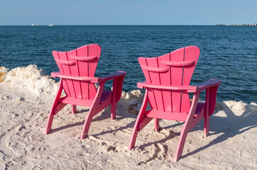 Two Pink Adirondack Chairs by the Beach
