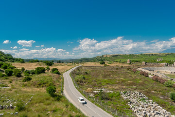 View from a height of the ancient city of Perge. Ancient city surrounded by dense green vegetation.