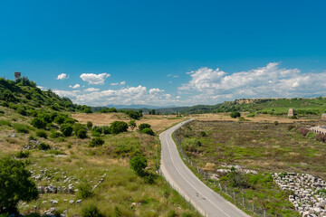 View from a height of the ancient city of Perge. Ancient city surrounded by dense green vegetation.
