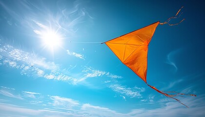 Yellow kite flying high in a clear blue sky, closeup, freedom, carefree joy