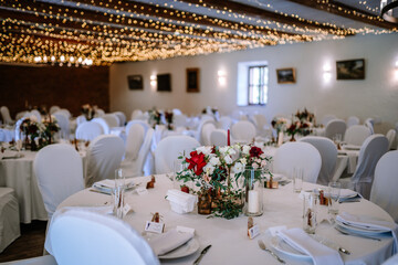 Valmiera, Latvia - August 19, 2023 - Elegantly set wedding reception tables with white chairs,...
