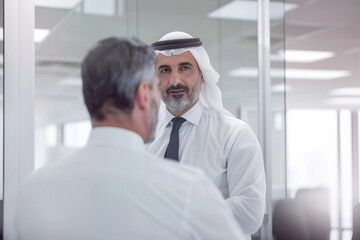 Fototapeta premium In the pristine setting of an office, a mid-aged mature business man, a confident professional investor, engages in a meeting with a billionaire Arab Sheikh. As he offers consultan