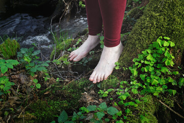 Woman is walking barefoot in forest area. Grounding and nature connection.
