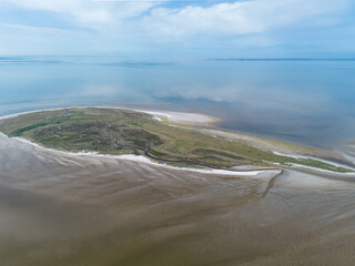 Aerial drone image of the uninhabited island Griend, part of world heritage the Wadden Sea in the Netherlands. Bird sanctuary, protected site, dunes, tidal stream, beach and sand bank in reflection