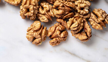 Obraz premium macro shot of scattered walnuts on white marble table top view