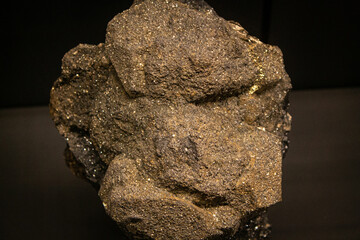 Macro close up of golden send shining stone. Black background Isolated gemstone, particle element...