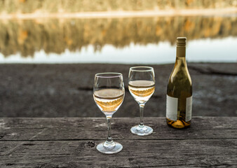Enjoying bottle of wine by a relaxing nature lake setting 