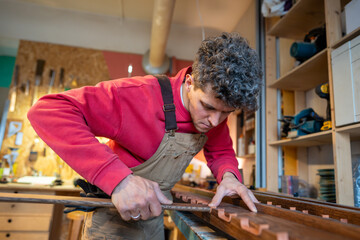 Concentrated male carpenter busy working in handmade production. Focused joiner man on woodworking...