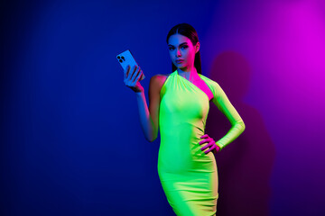 Photo of charming skinny figure model girl hold apple smart phone empty space isolated on vivid neon background