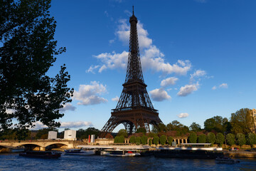 Fototapeta na wymiar Eiffel tower on Seine river, Paris, France. Scenic view of Paris in summer. Residential barges and tourist boats on the Seine in Paris .