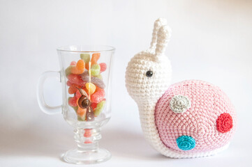 Colorful candy in a glass with a snail doll