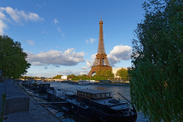 Eiffel tower on Seine river, Paris, France. Scenic view of Paris in summer. Residential barges and tourist boats on the Seine in Paris .