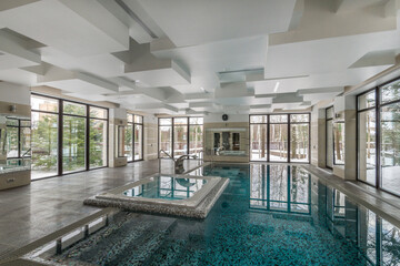 Spacious indoor private pool with artificial waterfall. A room with an original ceiling and .panoramic windows.