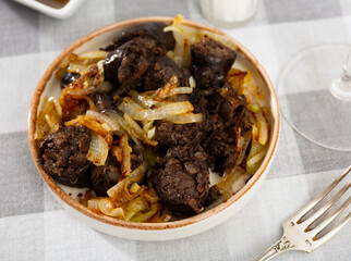 Grilled traditional Spanish morcilla blood sausage slices with rice served with onions..