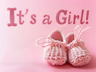 Woolen shoe in pink with Its a girl font. Gender reveal.