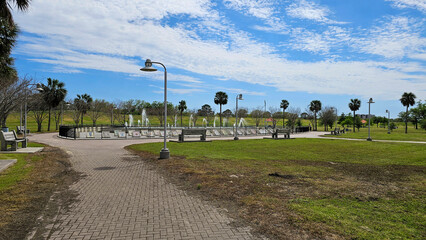 a gorgeous spring landscape at the Mardi Gras Fountain with a water fountain, lush green trees and...