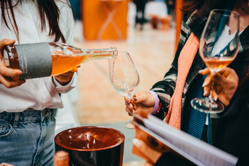 Sommelier pouring wine for wine tasting in a bar of restaurant or wine expo.