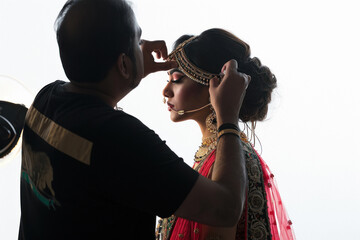 Young beautiful woman doing make up from professional make up artist
