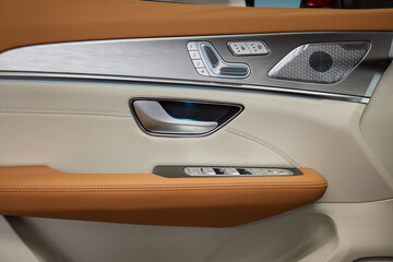 Closeup of car door with brown leather, silver trim