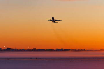 The plane takes off at dawn in heavy fog in winter