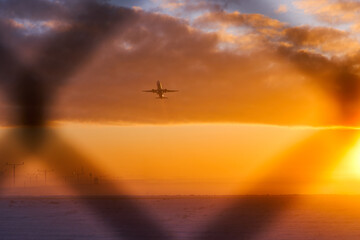 The silhouette of an airplane during takeoff in a protected area behind a fence. The concept of air...