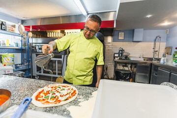 chef adding olive oil to the pizza and getting ready for baking, pizzeria. High quality photo