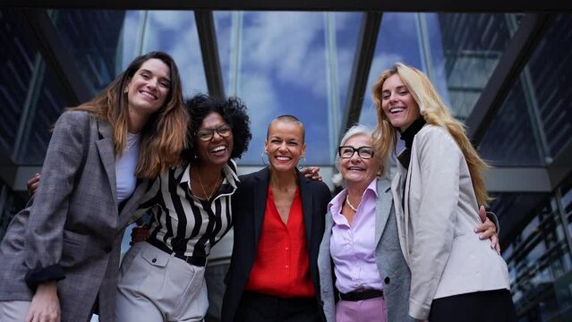 Portrait of multiracial and diverse ages business women in formal suits posing smiling with arms crossed looking at camera. Empowered and successful female entrepreneurs happy and powerful outdoor