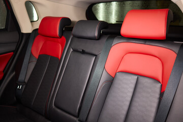 Red and black seats in the back of the car, part of the automotive design