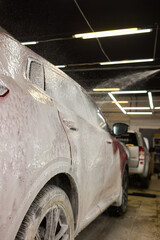 Closeup of red car foamed by liquid, resembling vibrant carmine artwork
