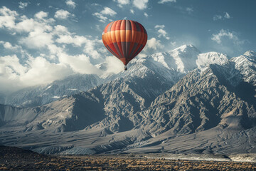 Fototapeta premium A single balloon drifting against a backdrop of a majestic mountain range, showcasing the beauty of nature.