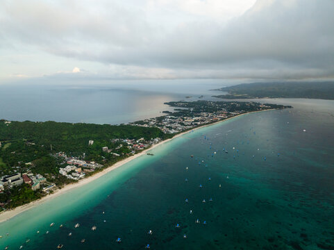 Aerial view of white beach path with powdery sands. Boats over clear turquoise water in Boracay, Philippines.