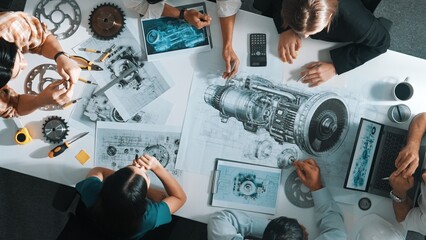 Top down aerial view of smart engineer team working together to design turbine engine. Professional...